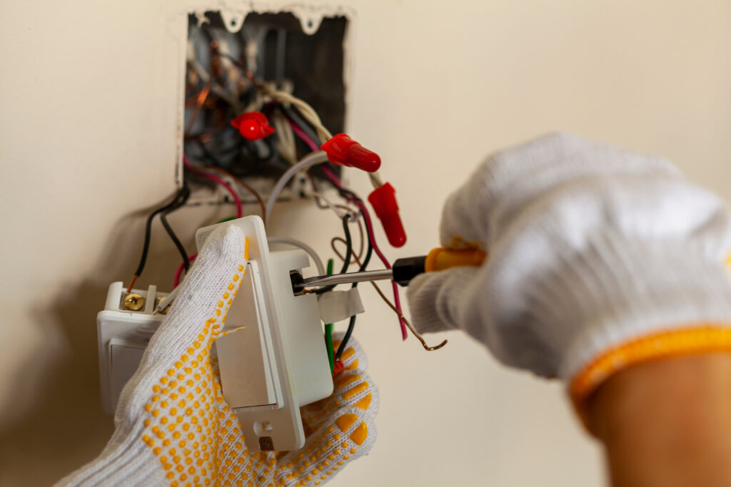 An electrician is replacing a wall switch. A DIY project concept
